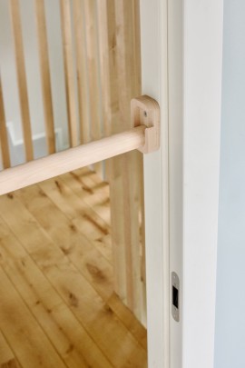 zamontowany w drzwiach drewniany drążek do podciągania typu PullUp Nuki w kolorze naturalnym